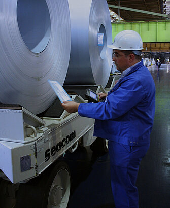 Employee checks quality of sheet metal rolls